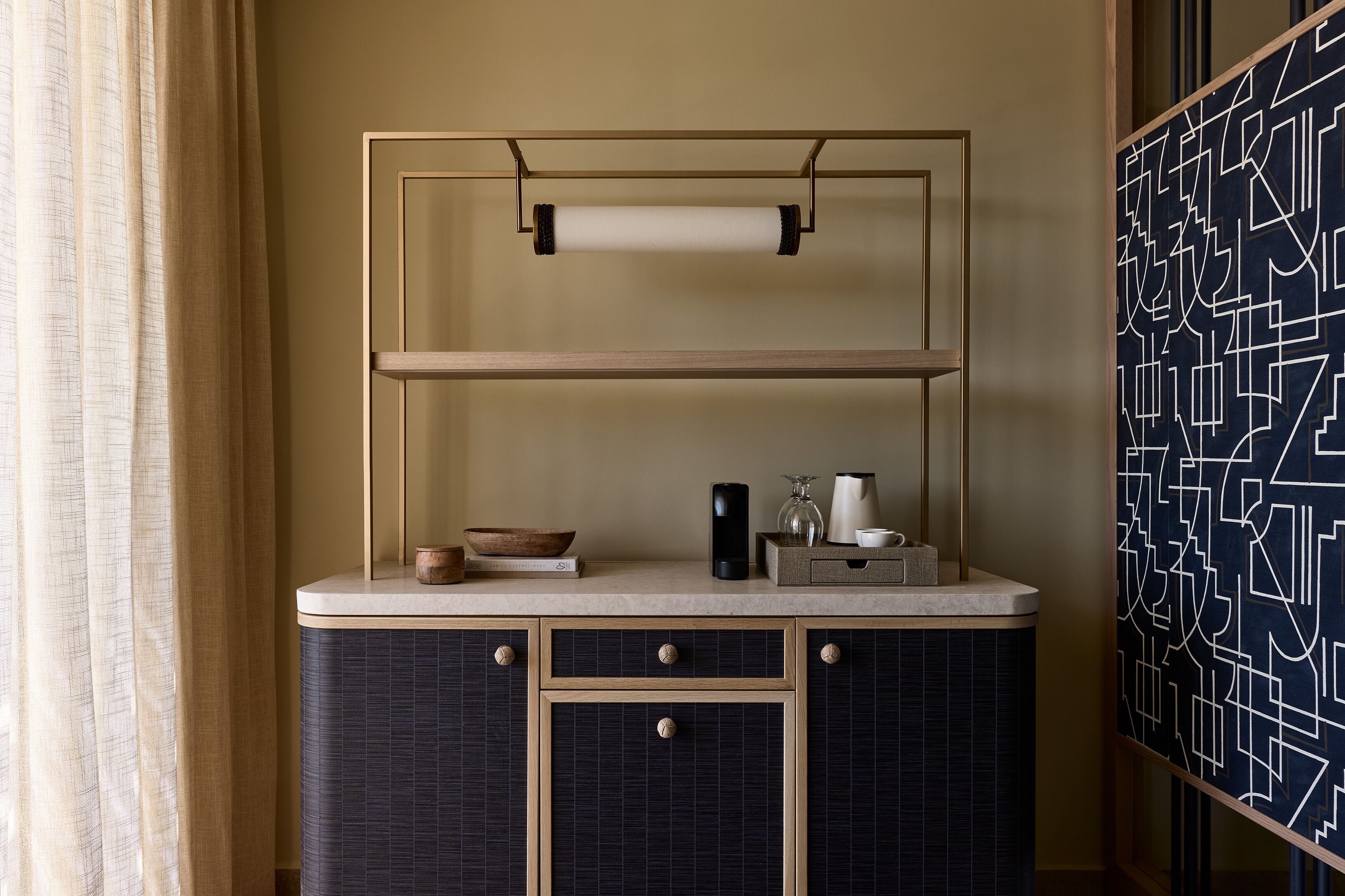 A kitchen with a countertop, a hanging towel, and a decorative wall panel.