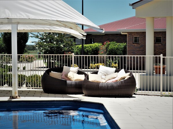 حمّام سباحة خارجي، مظلات على حمّام السباحة، مقاعد للتشمس