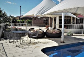 Una piscina al aire libre, sombrillas, tumbonas