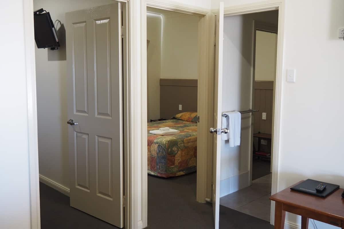 A hotel room with a bed, a small table, and a desk.