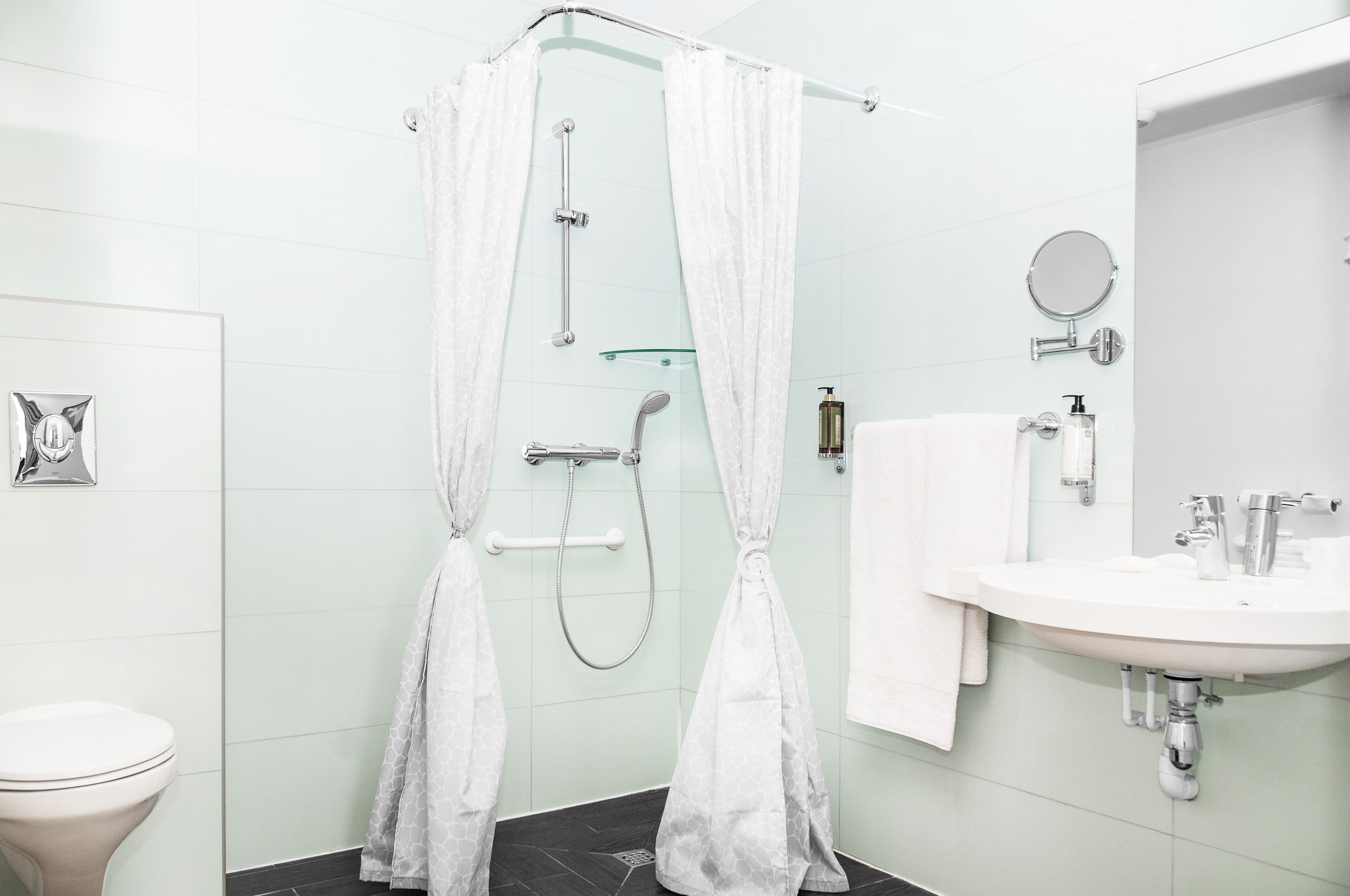 Un baño moderno con ducha, inodoro y lavamanos.