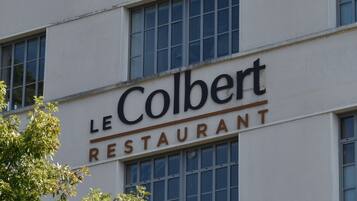 A building with signage for 'Best Western PLUS Hôtel Colbert' and 'LE Colbert RESTAURANT'.