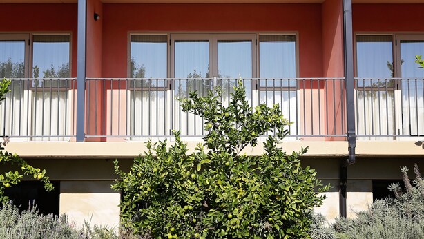 A two-story building with a balcony, large windows, and a small garden area. - Forbes Victoria Inn (Forbes)