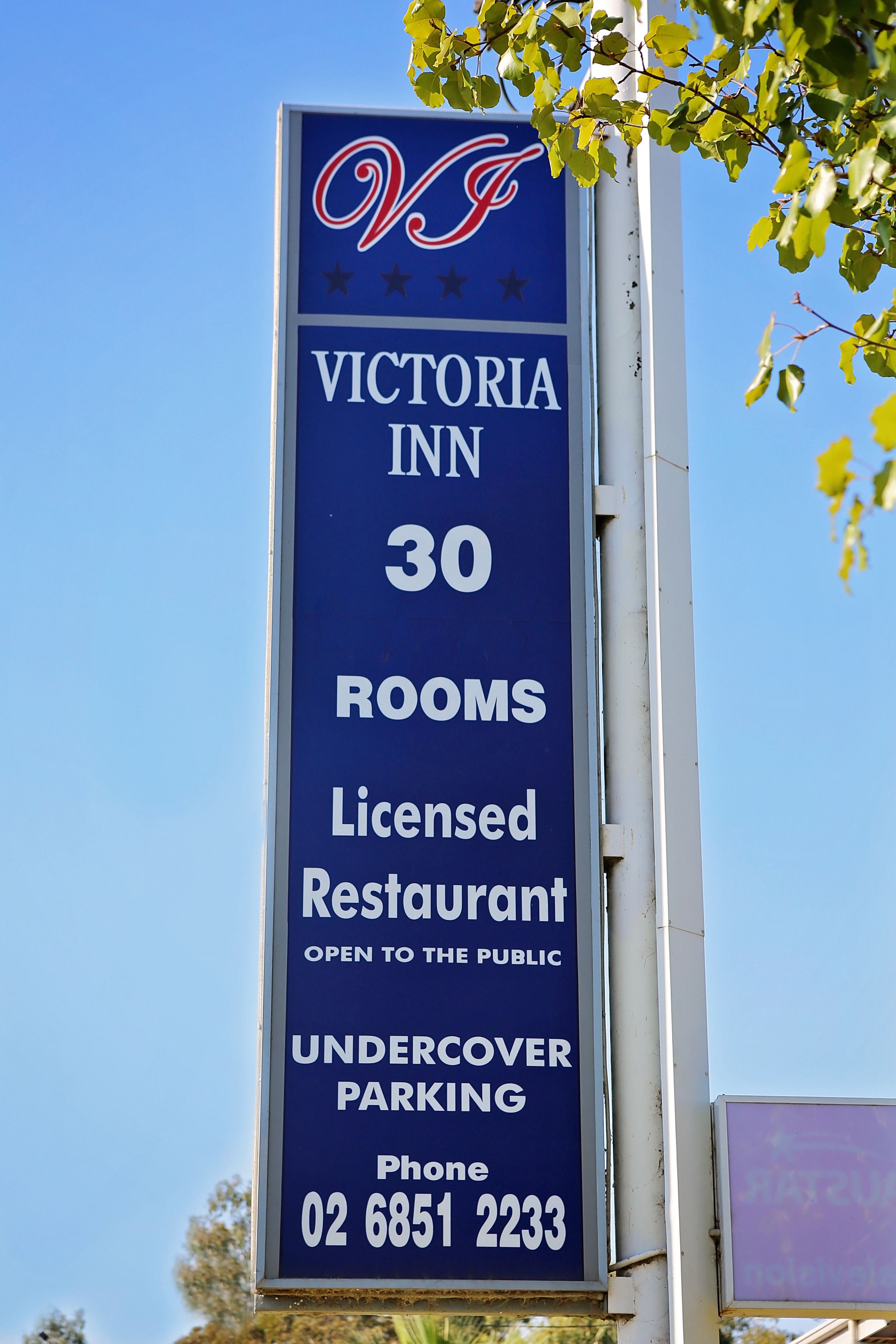 Bordje voor Victoria Inn, met informatie over 30 kamers, een restaurant met vergunning, openbare toegang en overdekte parkeerplaats.