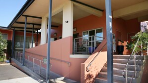 A building with a covered entrance, a staircase with metal railings, and a clear sky. - Forbes Victoria Inn (Forbes)
