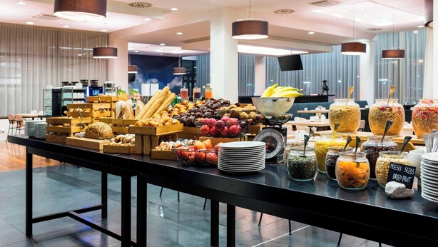 Un buffet proposant une variété d’aliments, notamment des fruits, des légumes et des céréales.