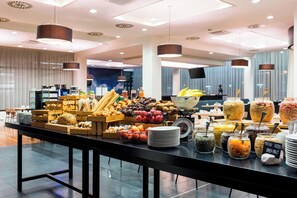 Un buffet proposant une variété d’aliments, notamment des fruits, des légumes et des céréales.