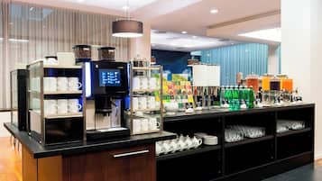 Un bar à petit-déjeuner moderne, équipé de machines à café, de distributeurs de thé et proposant une grande variété de boissons.