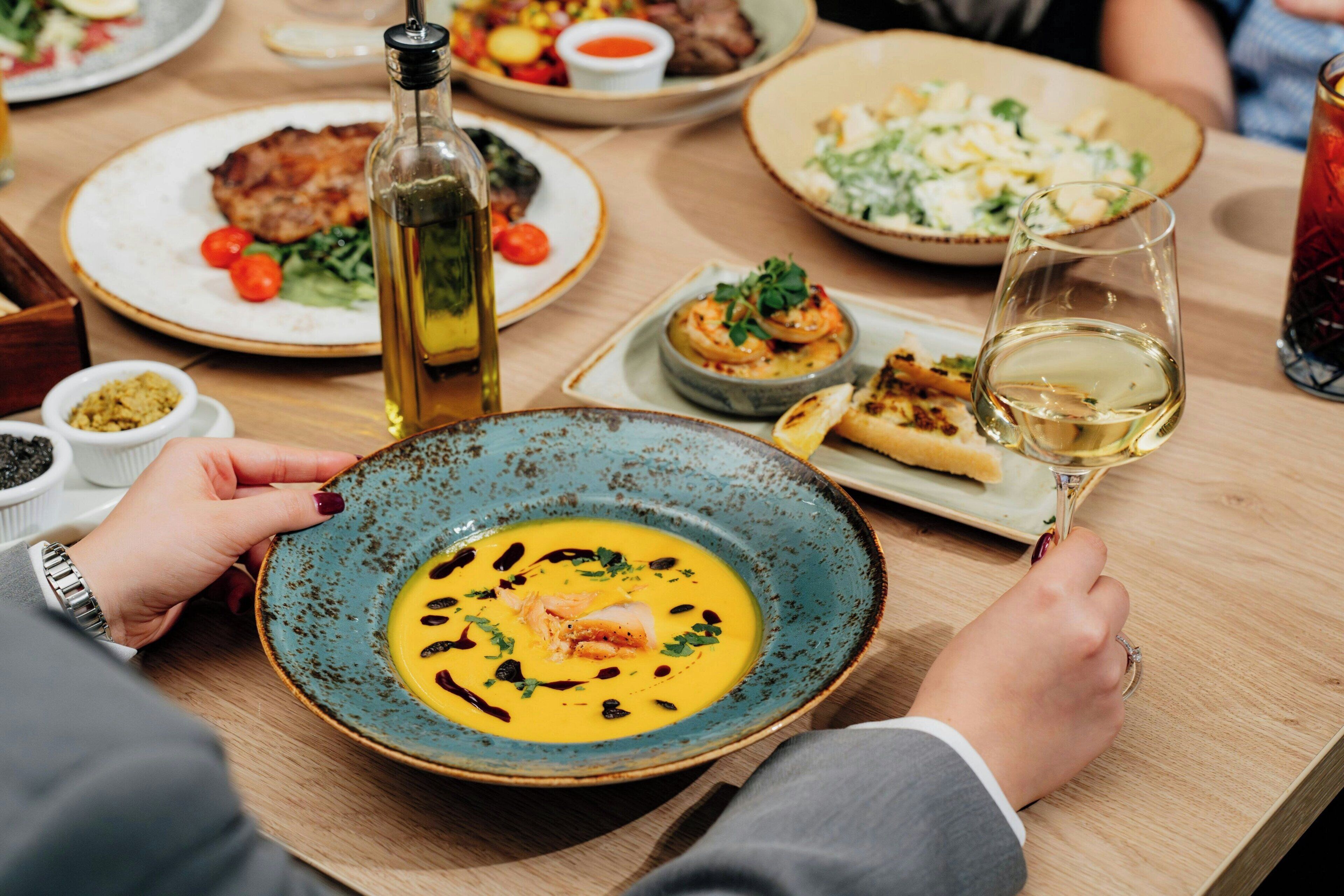 A dining table with various dishes and a bottle of wine.
