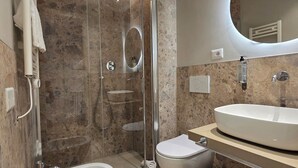A modern bathroom with a glass-enclosed shower, a freestanding bathtub, a toilet, and a vanity with a sink. - Hotel Porta Pia (Rome)