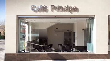A cafe named 'Café Principe' with a modern interior, visible seating area, and a glass entrance.