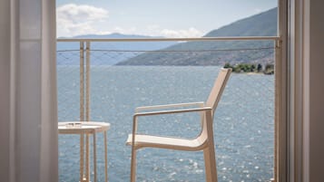 Ein Balkon mit einem Drahtzaun, einem einzelnen Stuhl und einem kleinen runden Tisch.