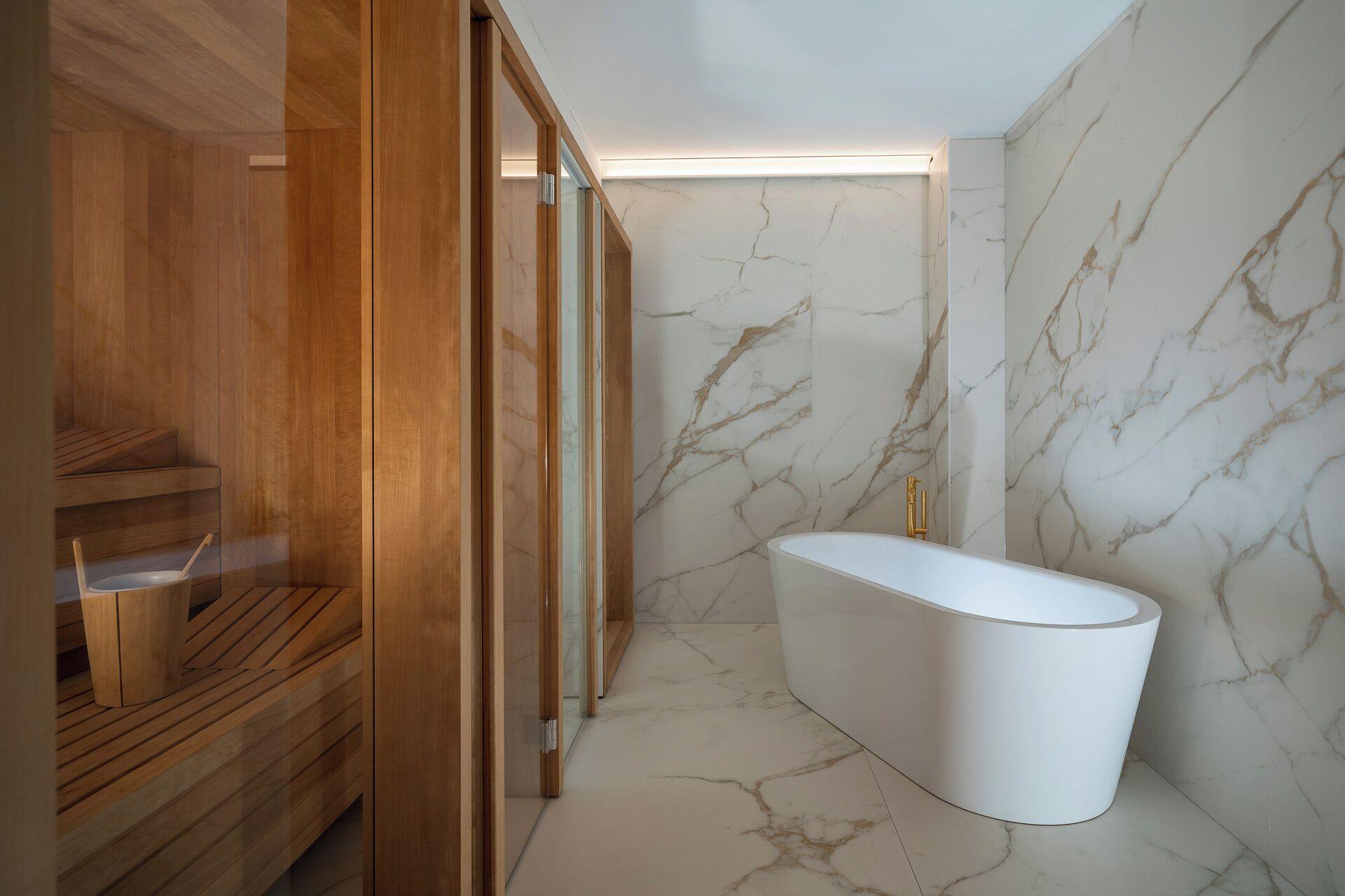 Un baño moderno con una bañera independiente, paneles de madera y paredes de mármol.