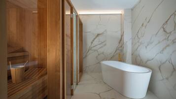 Un baño moderno con una bañera independiente, paneles de madera y paredes de mármol.