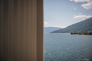 Vista de un lago con montañas al fondo y una pequeña isla con edificios.