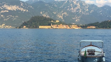 A boat on calm water with a mountainous backdrop.