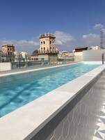 Una piscina al aire libre de temporada, sillones reclinables de piscina