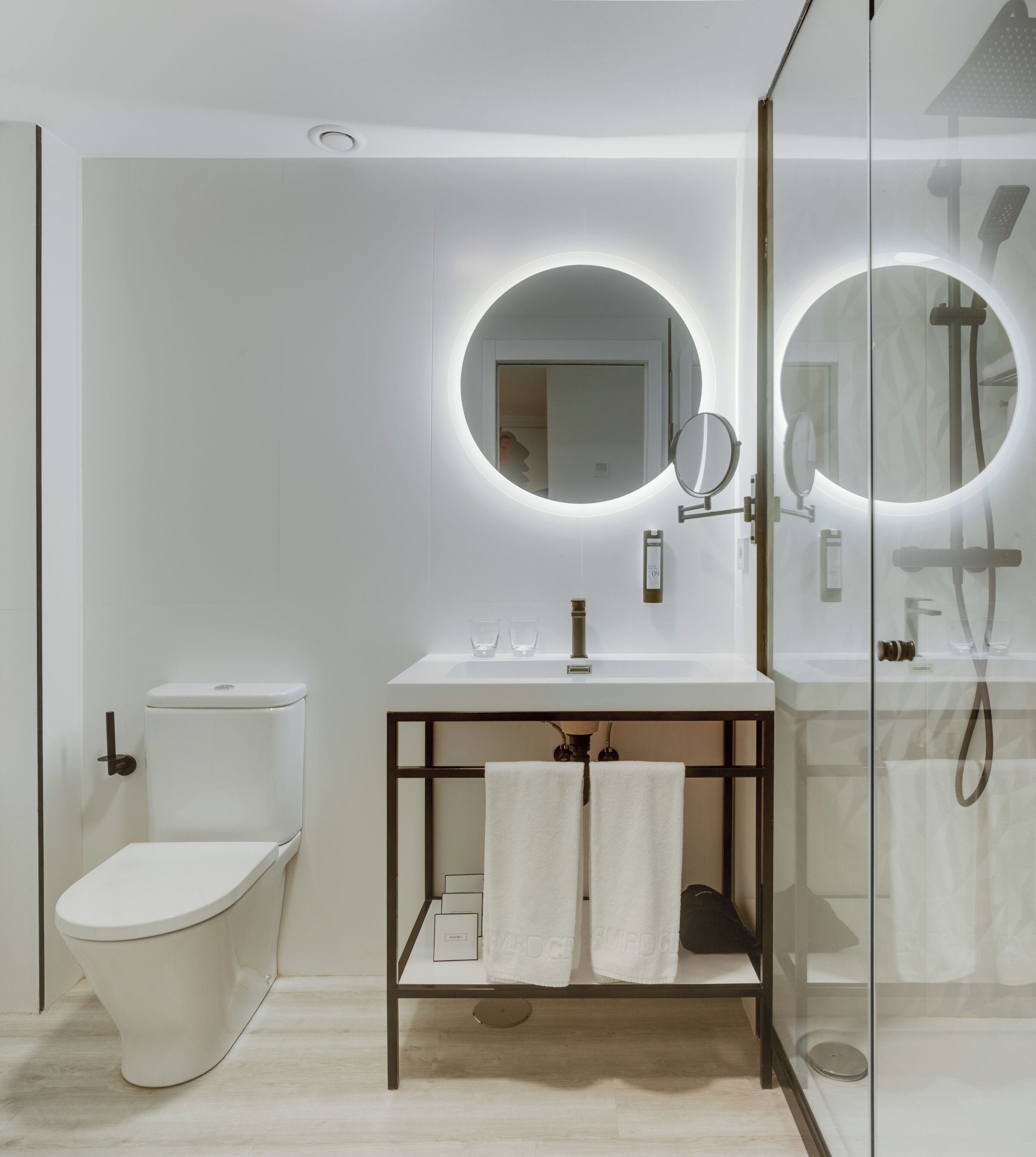 Un baño moderno con inodoro, lavamanos y ducha.