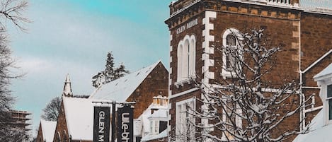 A historic building with a prominent tower and a sign reading "Glen MHOR."