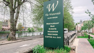 Letrero para The Waterside, un restaurante bar, eventos, bodas, reuniones y café disponible todo el día.
