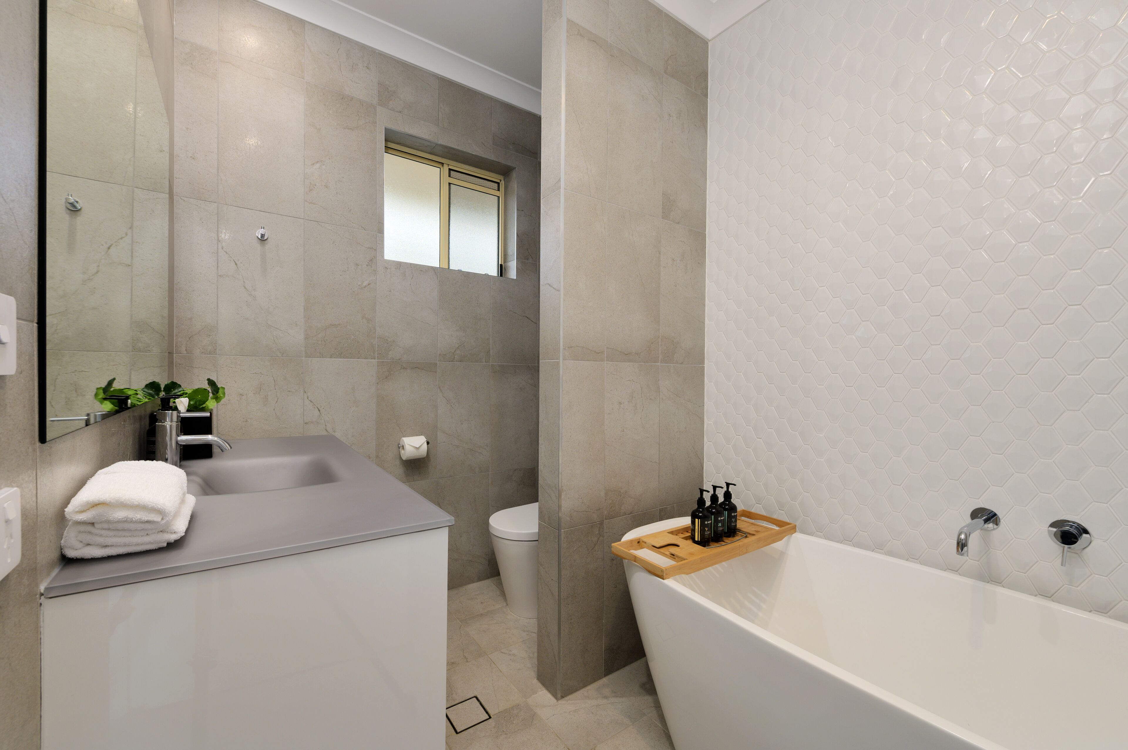 Un baño moderno con lavamanos, inodoro y bañera.