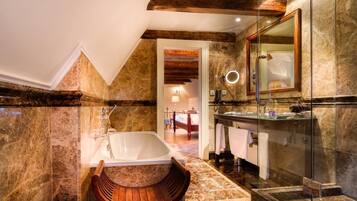 A modern bathroom with a freestanding bathtub, a glass-enclosed shower, and a large mirror.