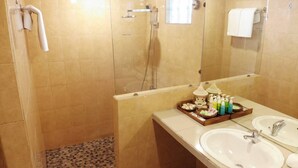 A bathroom with two sinks, a shower, and a mirror. - The Flora Kuta Bali (Kuta)