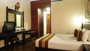 Une chambre d’hôtel équipée d’un lit, d’un bureau, d’une chaise et d’un miroir.