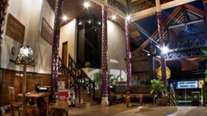 A spacious lobby with high ceilings, wooden columns, and a staircase leading to upper floors. - The Flora Kuta Bali (Kuta)