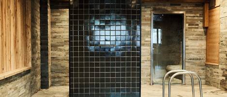 A spa area with a pool, wooden walls, and a tiled wall.