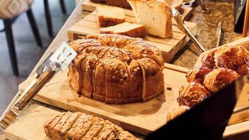 Une variété de pains et de viennoiseries présentés sur des planches à découper en bois.