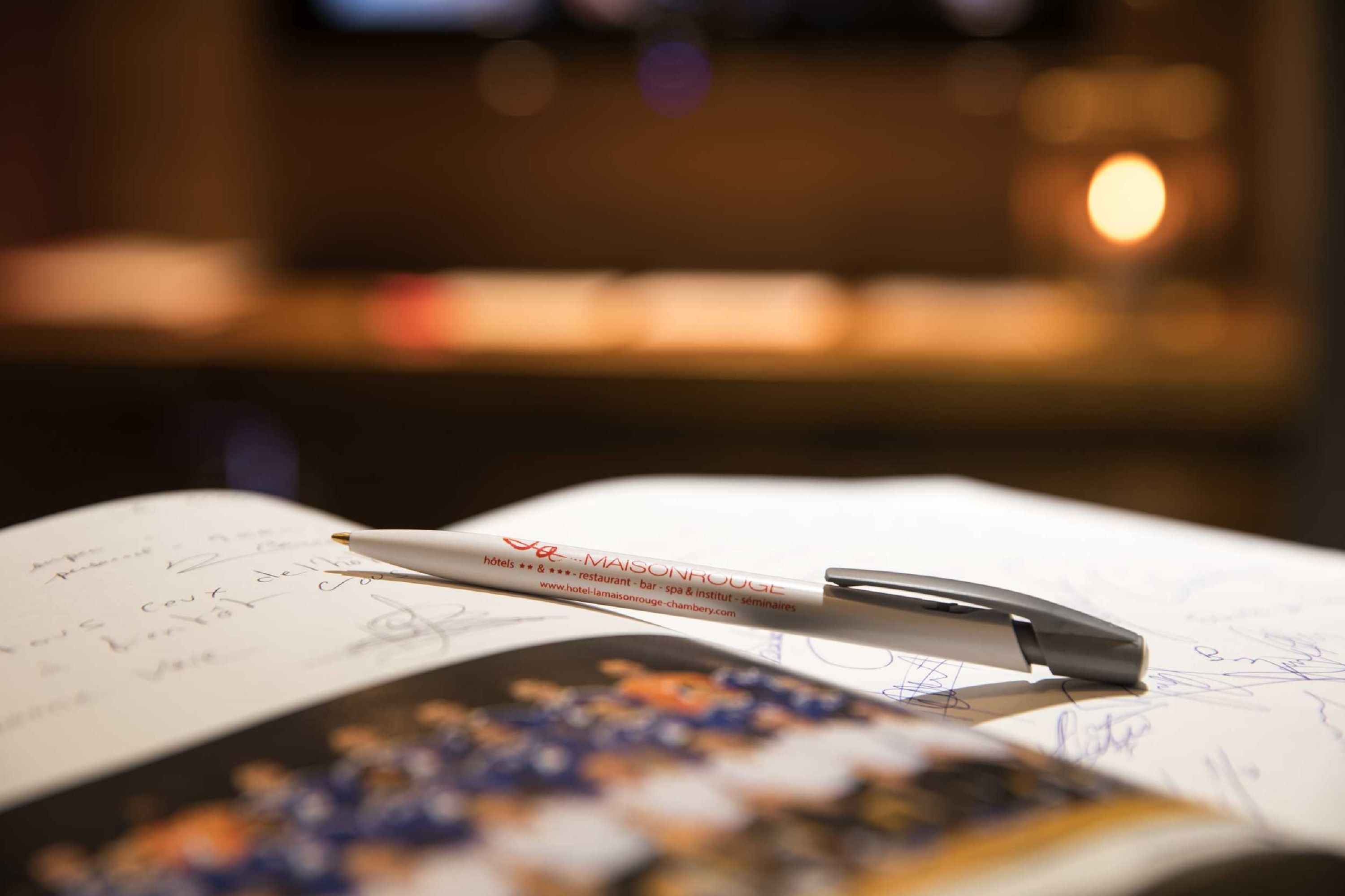 Un stylo posé sur une page couverte de notes manuscrites, avec un arrière-plan flou.