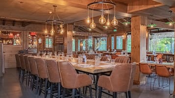 Un restaurant au décor intérieur en bois, doté de nombreuses tables et de luminaires suspendus.