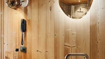 Un interior de madera con un lavabo de piedra, un espejo y un teléfono.