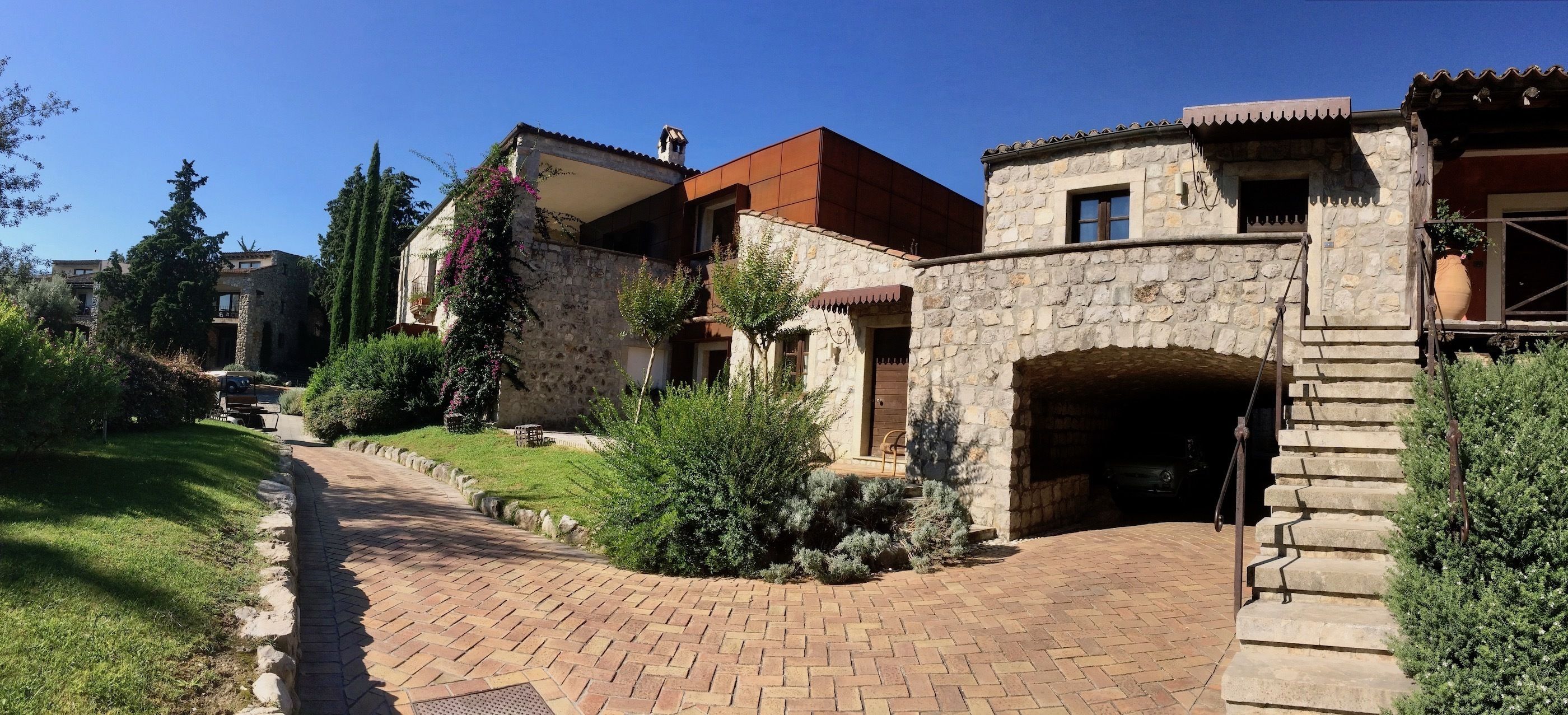 A stone building with a brick pathway leading to a covered entrance.