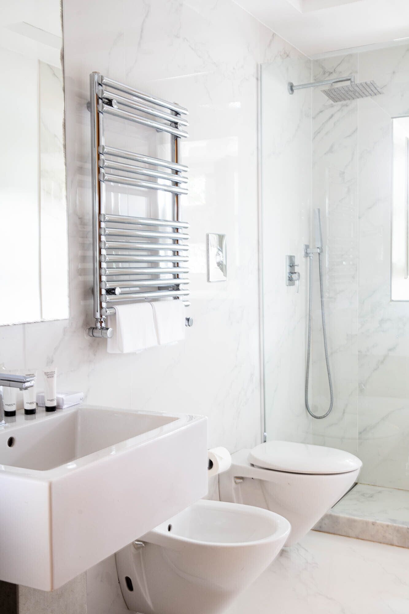 Un baño moderno con un lavamanos grande, inodoro y ducha.