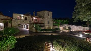 A stone building with a courtyard, a stone bridge, and a well-lit entrance.