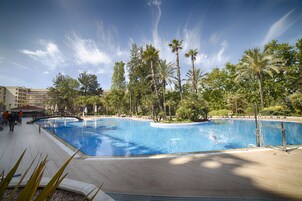 Una piscina cubierta, una piscina al aire libre, tumbonas