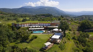 Un complexe hôtelier doté d’une piscine, d’un espace extérieur aménagé et offrant une vue sur les montagnes.