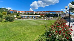 A hotel with a large outdoor area, a pool, and a restaurant.