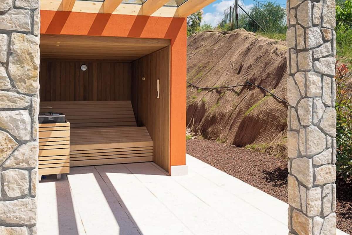 Un bâtiment moderne avec une façade en pierre, un intérieur en bois et un ciel dégagé.