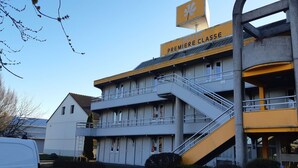 A multi-story building with a sign reading "HOTEL PREMIERE CLASSE".