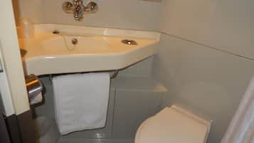 Un baño con un lavabo blanco, un inodoro y una toalla colgada en la pared.
