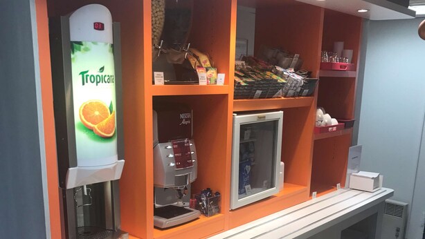 Ein Selbstbedienungskiosk mit Kaffeeautomat, einer Kühlvitrine sowie verschiedenen Snacks und Getränken.