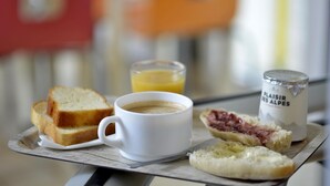 A breakfast tray with toast, a cup of coffee, a glass of orange juice, and a jar of jam. - Premiere Classe Dunkerque Sud - Loon Plage (Loon-Plage)