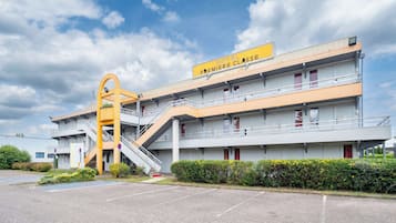Un hotel con un letrero amarillo que dice "HOTEL PREMIERE CLASSE" y una escalera que lleva a la entrada.