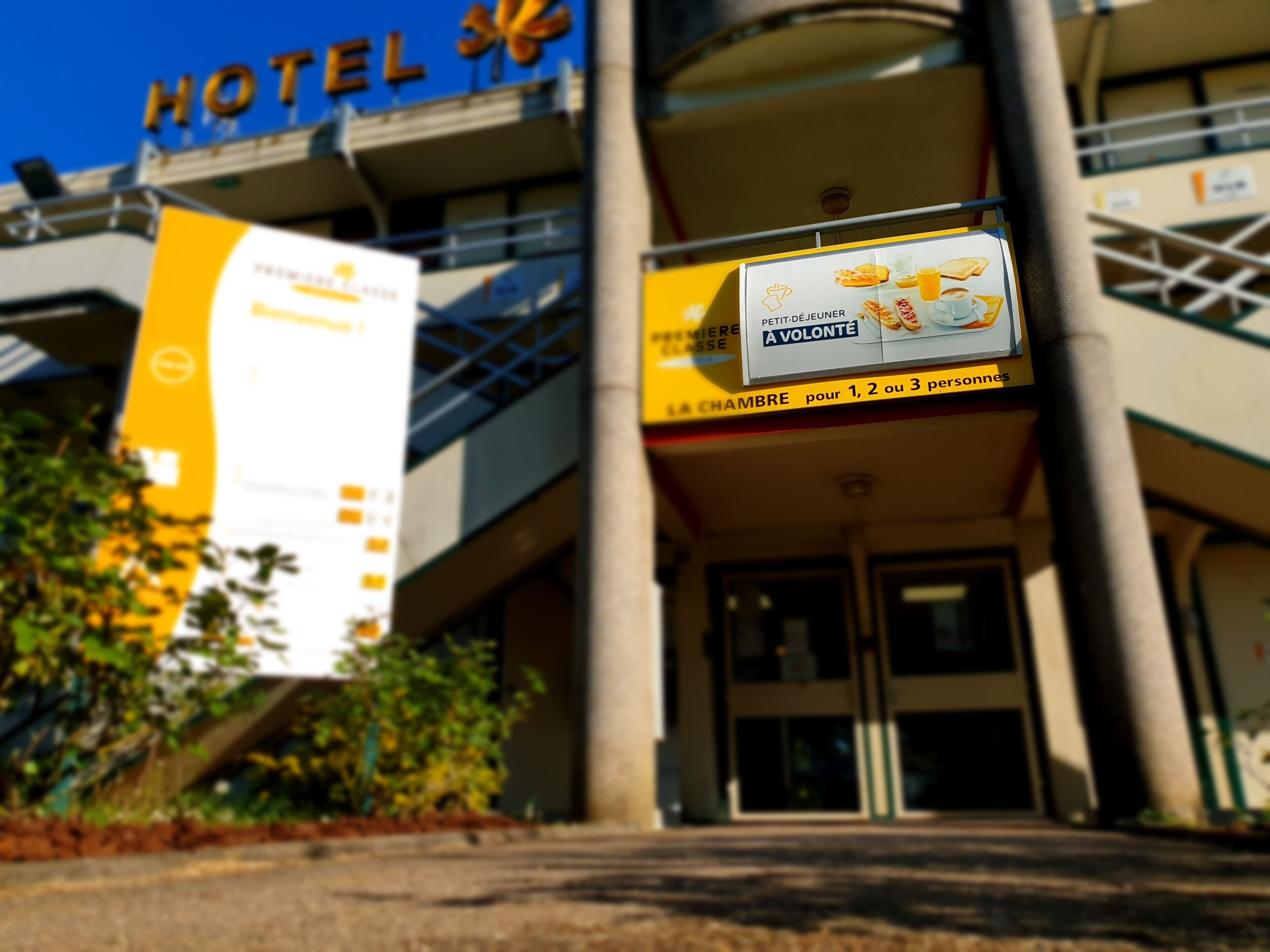 A hotel entrance with a sign advertising breakfast for 1, 2, or 3 persons.