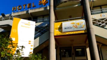 A hotel entrance with a sign advertising breakfast for 1, 2, or 3 persons.