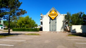 Un bâtiment avec une grande enseigne jaune sur laquelle on peut lire « Premiere Classe Hotels » et une entrée fermée par un portail.