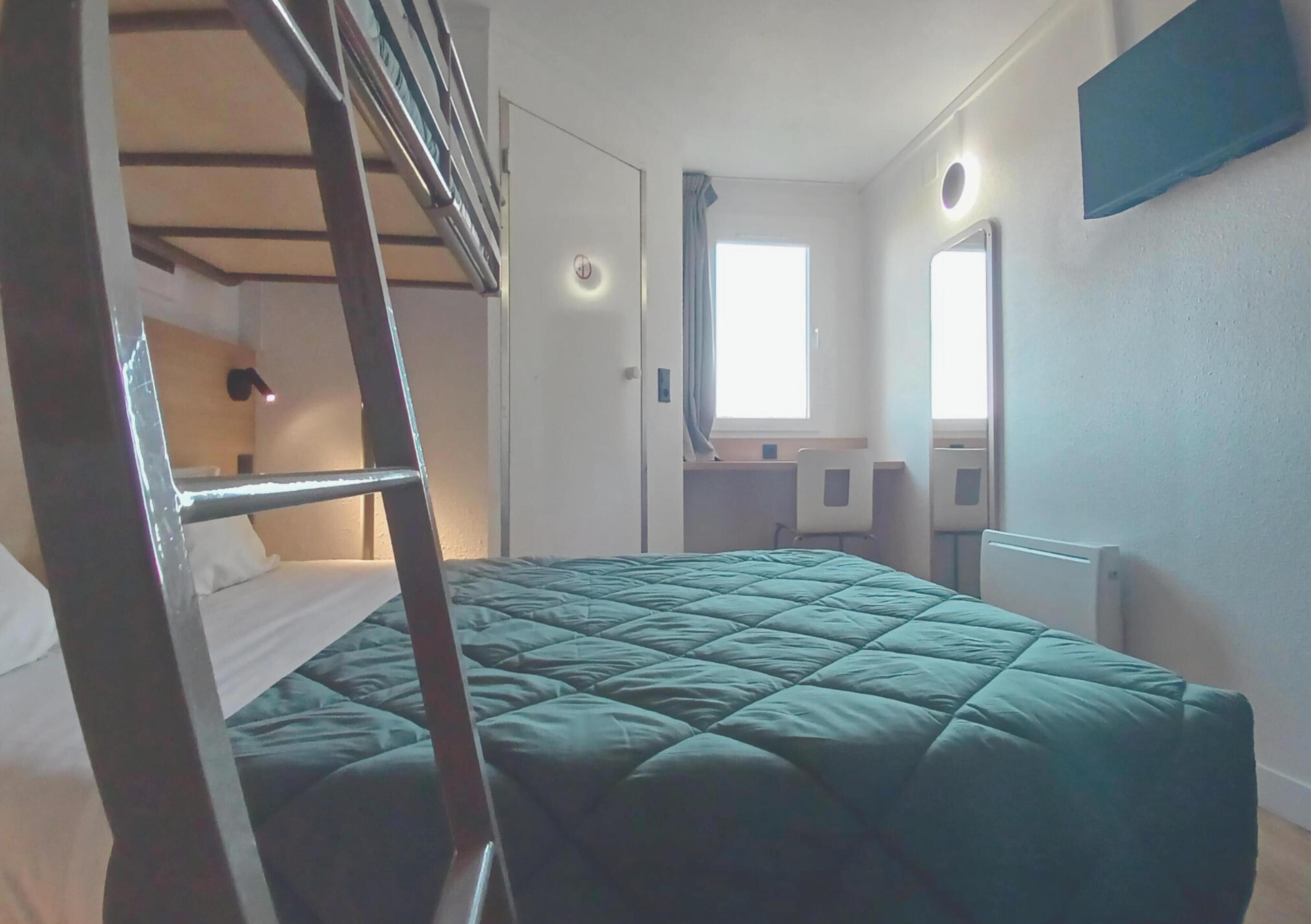 Une chambre avec un lit superposé, un bureau, une chaise, une fenêtre et un miroir.